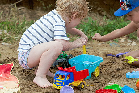 两个孩子在沙滩上玩塑料玩具玩具游戏闲暇童年晴天男生喜悦儿童白色沙坑沙箱活动图片