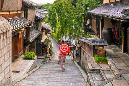 在京都老城 红伞横田的日本女孩旅行历史地标旅游楼梯爬坡天空路面店铺文化图片