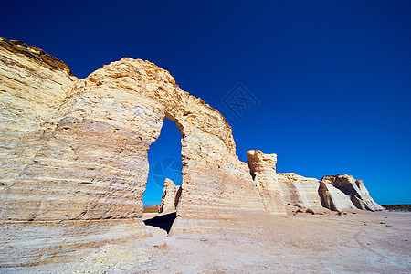 仰望着白色的岩石柱子 上面有拱形和明蓝天空图片