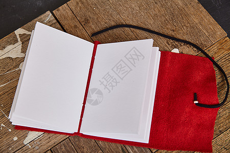 印有空白页和红色皮革软封面的公开草图手册图片