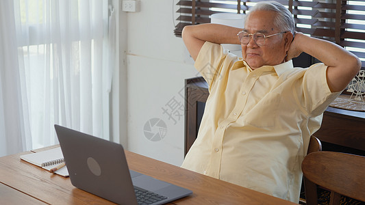 高级男子穿戴眼镜 坐在笔记本电脑工作椅上技术祖父互联网男人商业网络男性退休工人成人图片