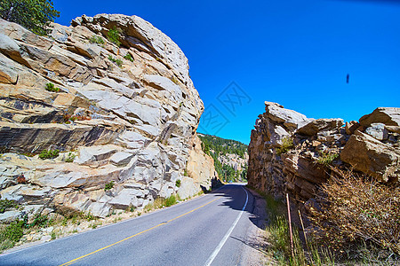 穿过岩石山的公路 有巨大的岩悬崖图片