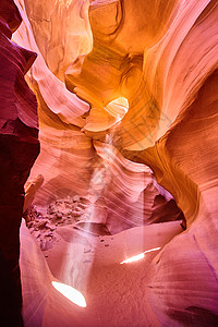 穿过橙色峡谷岩石的浅洞孔图片