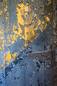 木制门的蓝色颜料皮 在下面显示亮黄色彩色图片