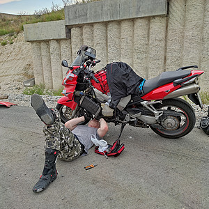 男子在公路上修理摩托车图片