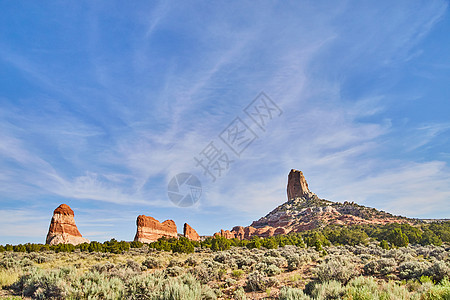 蓝天空 在沙漠绿地的沙漠中有红石柱图片