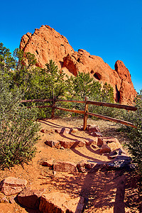 在沙漠道路上用木栅栏和大块红石对着蓝天空的石头踏在荒漠道路上图片