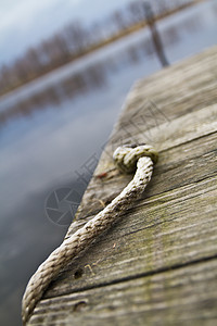 细绳附在木头码头上 挂在水的边缘图片