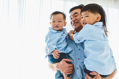 快乐的父亲带着两个孩子在他们家的卧室里 家庭生活和积极表达情感团结 空闲时间 人们的生活方式健康 检疫 Covid-19 冠状病图片