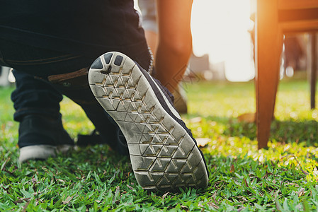 在准备出发前在公园里穿着跑鞋的人的特写 商业和体育概念 人与自然主题 绿草元素 后视图背景