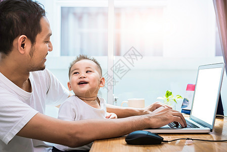 单身父亲和儿子一起愉快地使用笔记本电脑 技术和生活方式概念 幸福的家庭和婴儿主题童年爸爸女儿商业办公室男性互联网教育工作闲暇图片