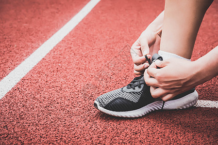 体育女子在体育场跑道上系运动鞋鞋带绳的特写 体育中心和健身健身房的概念 健康和身体建立主题 运动装和时尚主题图片