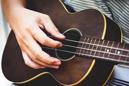 弹吉他的吉他手手特写镜头 乐器的概念 户外和休闲主题 在左手上的选择性焦点 复古乡村民谣吉他与音乐歌手 特写了艺人的手乐队娱乐玩图片