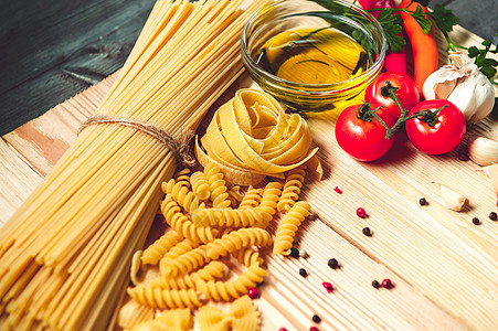 美味可口的意大利面条面食配料 用于厨房烹饪 配以番茄 帕尔马干酪 橄榄油 宽面条和罗勒 放在棕色木桌上 食物意大利食谱自制 顶视图片