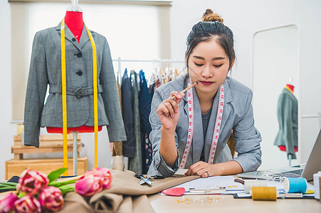 在家庭办公室车间工作的迷人亚洲女性时装设计师 时尚的时尚达人女性创造新的布料设计系列 裁缝和缝纫 人们的生活方式和职业概念裙子人图片