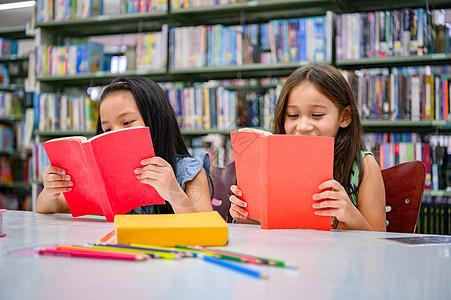 幸福两个可爱的多样性女孩在学校图书馆看书很有趣 人们的生活方式和朋友教育和友谊的概念 休闲儿童和儿童团体活动图片