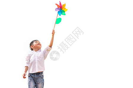 男孩在户外风中抓着多彩的针轮 儿童肖像和玩主题游戏的儿童 在白色背景上孤立无援图片