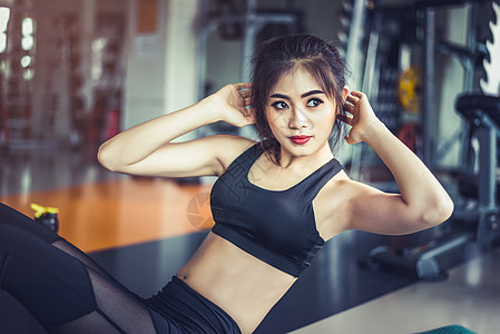 亚洲健身女孩在健身房做嘎吱嘎吱的侧视图 运动和锻炼的概念 健身房和美容主题图片