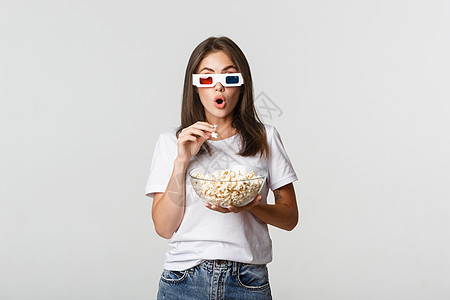 令人兴奋和印象深刻的美美女孩 吃爆米花 看电影 在3D眼镜监视广告情感手势快乐学生青年发型黑发成人图片