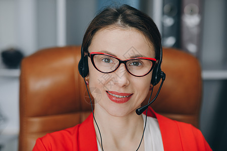 具有在线教师概念的视频聊天工作面试或远程语言课程 快乐的年轻女性戴着耳机 通过电话会议说话 在家办公室看着电脑图片