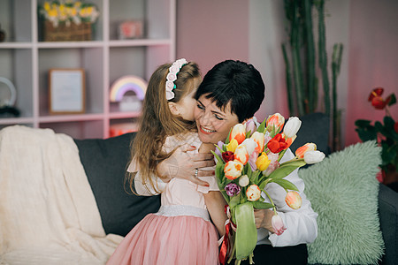 母亲节快乐 亲吻和拥抱幸福的家庭 美丽的母亲和她的小女儿 在母亲节 微笑的白人高级母亲与她成年的女儿拥抱和亲吻父母妈妈郁金香女孩图片