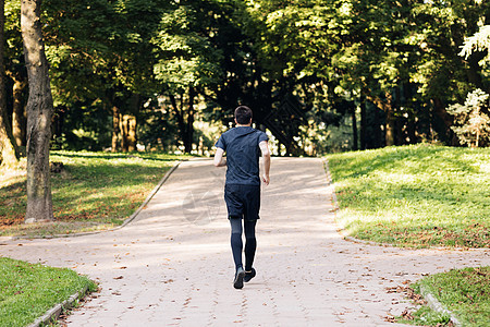穿着运动服的成年男子清晨在公园慢跑 体育人 运动员 跑步活动 健康的生活方式城市晴天景观头巾运动培训师绷带男性男人运动装图片