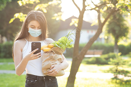 社交隔离 送外卖 妇女在检疫期间戴口罩预防冠状病毒 使用手机的女人 大流行图片