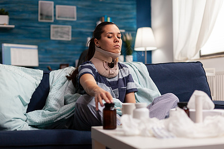 坐在沙发上的有子宫颈颈领的妇女长椅椎骨脊柱药品问题痉挛伤害颈椎病痛苦治疗图片