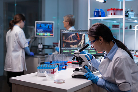 生物化学科学家研究实验室显微镜上病毒反应的生物化学学家图片