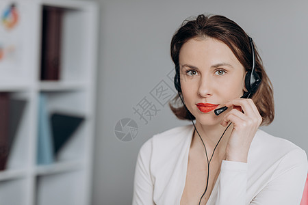 美女呼叫中心在向客户咨询在线问题时佩戴耳机并使用计算机 支持和运营商服务业务代表概念 网上营销图片