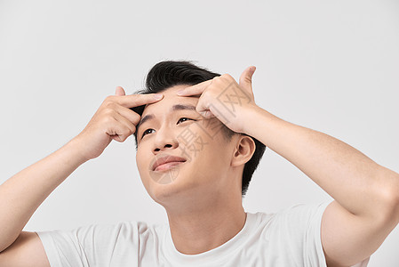 年轻男子在寻找脸部的Acnes的照片男人男性成人奶油卫生皮肤治疗护理粉刺背景图片