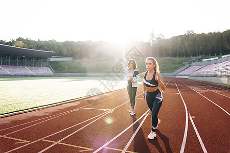 女赛跑者与私人教练准备在体育场运动跑道上的雾中起飞 比赛前训练 白种人运动员准备开始 女运动员 有氧运动图片
