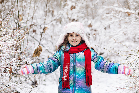 快乐的小女孩在下雪的冬天散步时玩雪 冬日快乐 快乐的年轻女孩的快乐冬日时光 长着黑发 冬衣在下雪时玩得开心图片