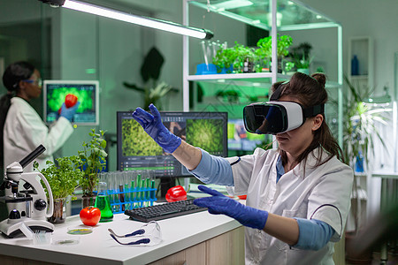 身穿虚拟现实头盔的科学家女研究员化学家制药技术实验生态微生物学团队生物学家生物试管图片