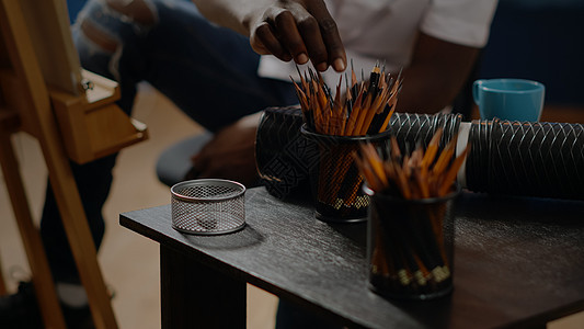 黑手用彩色铅笔在桌上贴近黑手图片