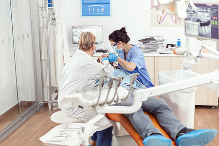 医院牙医小组为准备口腔外科手术的病人打扫牙牙男人面具牙齿老年工具牙科医生诊所药品考试图片