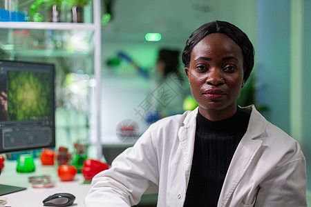 特写非洲生物学家女性看摄影机的近身植物技术保健生态食物医生生物学制药科学外套图片