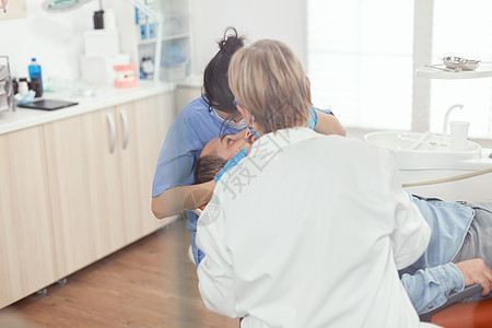 病人在口腔科治疗期间坐在牙椅上 张开嘴牙疼牙医乐器助手程序访问药品办公室考试男人图片