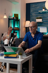 在现代家庭放松的残疾退休人员视频男人幸福笔记本问候语微笑养老金互联网女士会议图片
