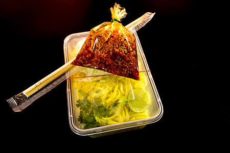 带酱汁的意大利面条 用塑料包装将食物带回家托盘美食筷子红色盒子图片