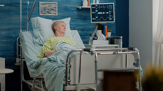生病的老年病人在医院床上躺床图片
