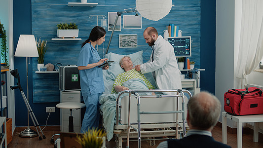医生和护士咨询在医院床上躺床的退休妇女图片
