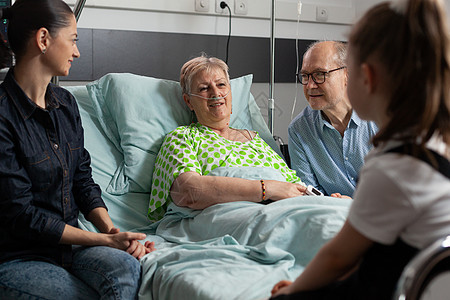生病的退休老奶奶在睡觉时与孙女交谈卫生病人长老祖父快乐祖父母女孩游客房间保健图片