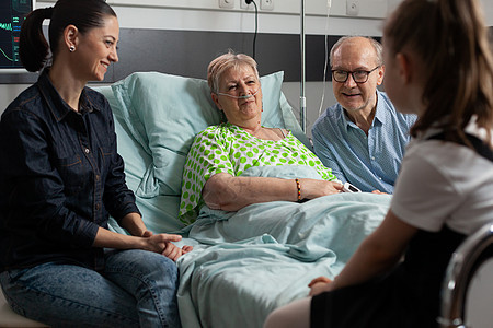 支持生病的祖母在医院病房探视她的家庭幸福快乐 单位 周房间孙子长老治疗疾病访问诊所外科女士说谎图片