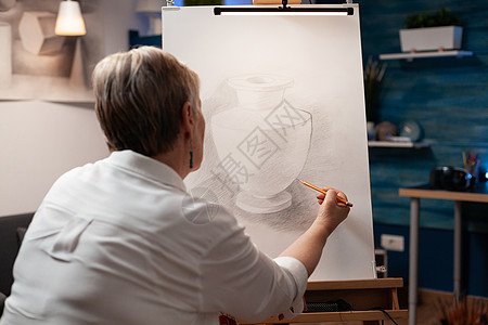 七彩铅笔近身的老年妇女用铅笔在画布上画花瓶杰作工作室房间职场女士工艺长老作坊创造力艺术背景