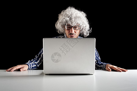 一台以高级专线为重心的潮车在办公桌旁坐着看笔记本电脑工作男人长老老年格纹上网网络困惑商业互联网图片