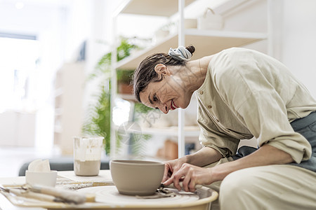 女士们坐在板凳上 用陶器轮子做泥锅作坊陶艺家工匠人手艺术车轮手工材料艺术家陶瓷图片