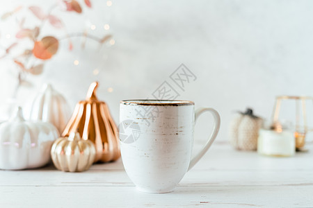 静物的细节 一杯茶或咖啡 南瓜 蜡烛 白桌背景上带叶子的早午餐 舒适房子里的家居装饰 秋季周末的概念 落叶和家居装饰房间感恩树叶图片