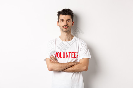 身穿白色T恤衫 举着手交叉胸前 看着摄像机 准备帮助的年轻男性志愿者公告服务组织捐款促销快乐情感机构社区志愿图片