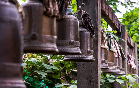 泰国佛教寺庙外面的木柱上连续挂着许多金属铃铛 排列着许多美丽的铃铛街道钟声信仰古董吸引力黄铜警报文化古钟运气图片